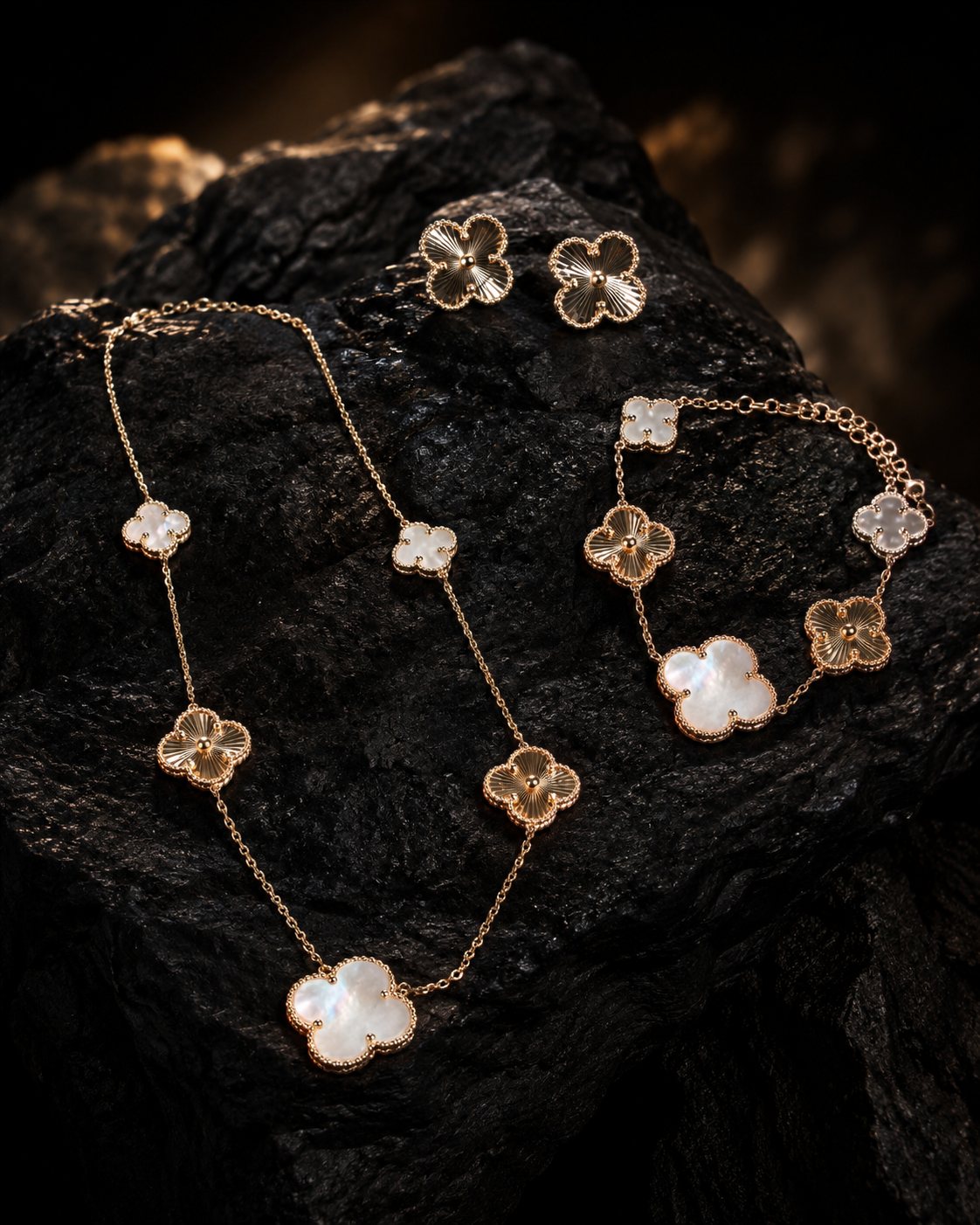 Conjunto de joyería dorada con motivos florales sobre piedra negra